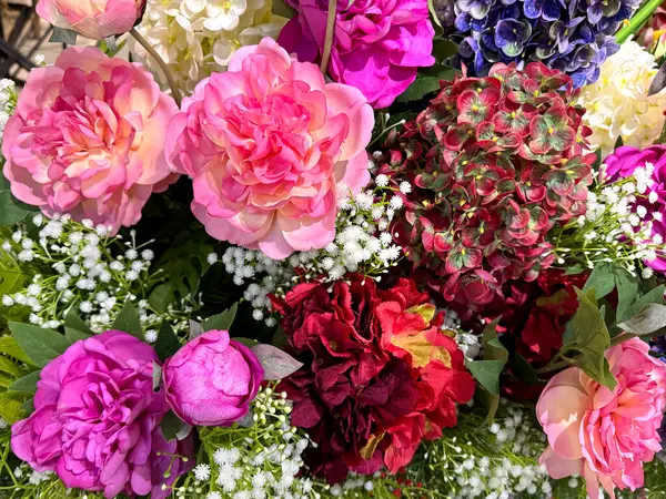 Dekoratif pembe ve mor taze çiçekler serisi düzgünce sergilendi. Gül, karanfil, kasımpatı ve çeşitli renklerde kadife çiçeği. Güzel bir çiçek dekorasyonu..