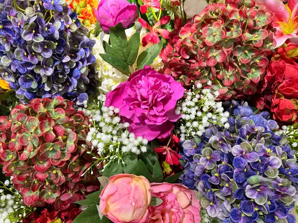 Dekoratif pembe ve mor taze çiçekler serisi düzgünce sergilendi. Gül, karanfil, kasımpatı ve çeşitli renklerde kadife çiçeği. Güzel bir çiçek dekorasyonu..