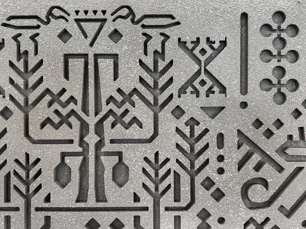 Gri bir duvara kazınmış rastgele etnik ve geleneksel desenlere yakın. Eski Mısır hiyeroglif dokusuna benziyor. Kadim kabile sanatı ve duvar süslemesi. Kusursuz arkaplan dokusu.