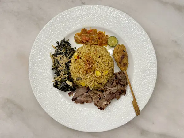 Balili karışık pirinci doğranmış domuz eti ve şiş ile yakın plan, salata sebze soslu. Beyaz bir tabakta, beyaz bir mermer masada servis edilir..