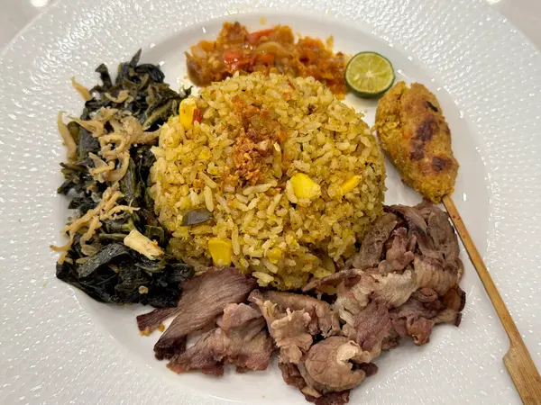 Balili karışık pirinci doğranmış domuz eti ve şiş ile yakın plan, salata sebze soslu. Beyaz bir tabakta, beyaz bir mermer masada servis edilir..