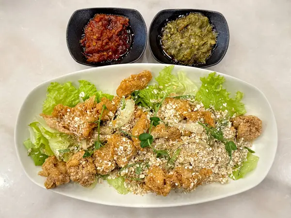 Marul ve sambal soslu buğday tavuğunu kapat. Buğday salamuralı tavuk, Güneydoğu Asya 'da ünlü bir yemektir. Beyaz bir tabakta servis edildi..