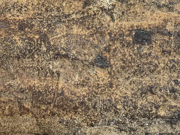 Paslı ve yıpranmış granit taş dokusunu kapatın, dış ve dış malzemeler için uygun. Oksitlenmiş ve altın bronz renginde çürümüş. Kusursuz taş arkaplan dokusu.