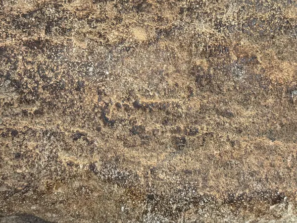 Paslı ve yıpranmış granit taş dokusunu kapatın, dış ve dış malzemeler için uygun. Oksitlenmiş ve altın bronz renginde çürümüş. Kusursuz taş arkaplan dokusu.