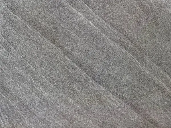 Gri renkli, rastgele koyu damarlı doğal taş kaplamaları kapatın. Kusursuz mineral taş arkaplan dokusu.