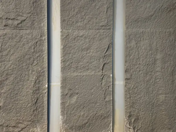 Gri renkli, rastgele koyu damarlı doğal taş kaplamaları kapatın. Kusursuz mineral taş arkaplan dokusu.