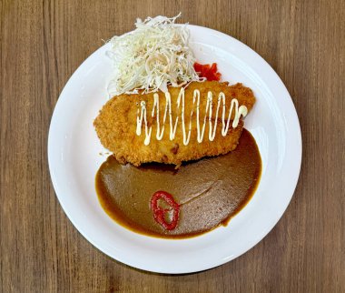 Japon lahana salatası ve meze ile körili dori balığını kapat. Beyaz bir tabakta servis edilir, ahşap bir masada izole edilir..