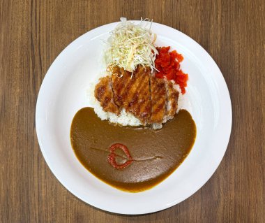 Japon lahana salatası ve meze ile körili tavuk yap. Beyaz bir tabakta servis edilir, ahşap bir masada izole edilir..