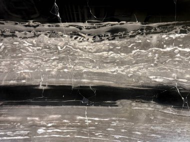 Doğal kara orman mermeri ya da siyah beyaz mermer levha deseni. Dalgalı beyaz damarları olan siyah bilye, kaba taş dokusu. Kusursuz arkaplan dokusu.