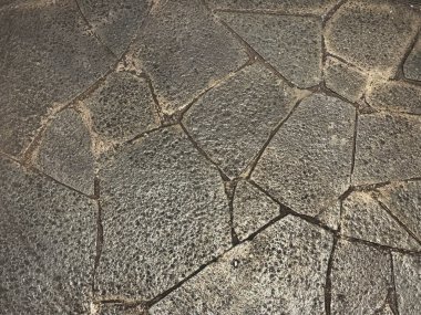 Rastgele kesilmiş gri döşeme taşı yüzeyde dümdüz olmuş. Ya da bir seri çakıl taşı gibi dümdüz olmuş ve pürüzsüz bir şekilde asfaltlanmış, zemin ya da duvar için.. 