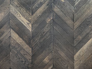 Sembol deseninde koyu ahşap döşeme. Koyu gri meşe ağacı ters sembol şeklinde düzenlenmiş. Kusursuz arkaplan dokusu.