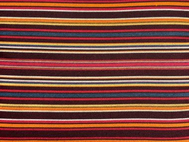 Kırmızı, mavi, sarı, beyaz, turuncu, çok katmanlı döşenmiş kırmızı halının kusursuz yakın dokusu. Kusursuz kırmızı çizgiler, çok renkli keten arkaplan. Halı dokusu.