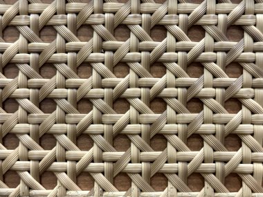 Örülmüş güzel sentetik rattan dokusunun yakın çekimi. Açık bej ve kahverengi renkli hasır sanatı ya da rattan dokuma sanatı. Kusursuz doku.
