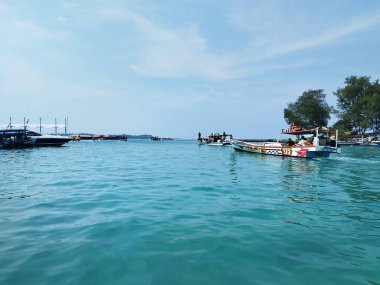 View of ocean with tourist boats with blue water. Tourist spot of cruising and rowing the boat around the beach shores. Tourism now declined with economic uncertainty.