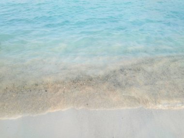 Mavi okyanus suyunun beyaz bir kumsalda dalgaları sıçrattığını görmek. Su dalgası fotoğrafçılığı, doğanın güzelliği. 