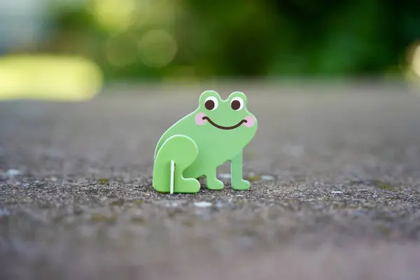 stock image Small cute green frog cardboard figure. Animal figurine toy. 2024.