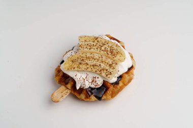 Kruvasan waffle ya da karamel, çikolata sosu, muz dilimleri ve üstüne krema..