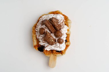 Çikolata, çikolata sosu ve kremşantili kruvasan waffle ya da bükülmüş waffle.