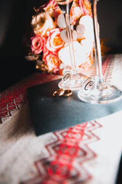 Kristal şampanya kadehlerinin dibinde yatan iki alyans romantik bir düğün ortamı yaratıyor. Alyanslara odaklan, geçmişi bulanık.