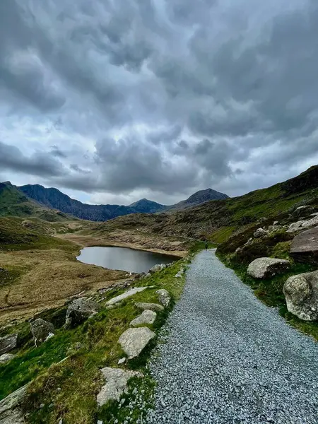 Yr Wyddfa, bulutlu bir günde, madenci yolunda, kardan tepeye giden yol, en alttaki göl manzarası....