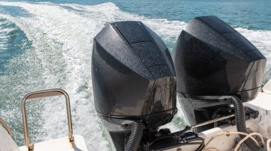 Sürat teknesinin arkasına monte edilmiş iki yüksek güçlü motor suda güçlü dalgalar oluşturuyor..