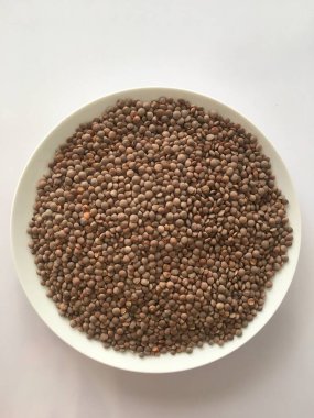 Kurutulmuş sabut masoor. İzole edilmiş beyaz arka planda Hint kahverengi mercimekleri