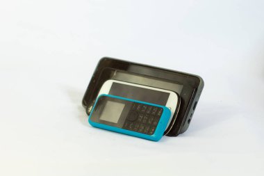 Bazı telefonlar eğilmiş ve fotoğraflanmış. Yan bir açıdan, izole edilmiş bir arkaplanda.