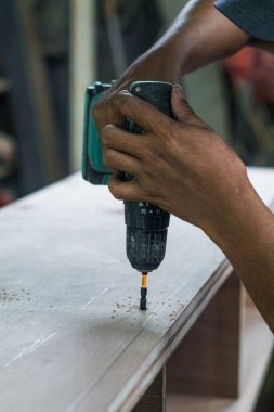 Endonezya, 2 mei 2025, mobilya yaratmak için kontrplak sondajı, vida, panel ya da diğer doğrama metodları için delik açmayı içeriyor. Bu süreç sağlam ve iyi hazırlanmış kontrplak mobilyaların montajı için çok önemlidir., 