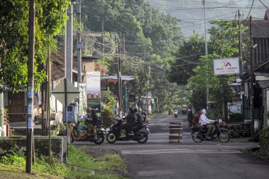 Endonezya, 2 Mei 2025, Tamiajeng, Trawas 'daki bir köy yolunda tipik sabah trafiğine tanık olun. Bölge sakinleri güne başlarken, yerel ve günlük hayatı tecrübe edin..