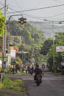 Endonezya, 2 Mei 2025, Tamiajeng, Trawas 'daki bir köy yolunda tipik sabah trafiğine tanık olun. Bölge sakinleri güne başlarken, yerel ve günlük hayatı tecrübe edin..