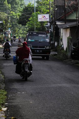 Endonezya, 2 Mei 2025, Tamiajeng, Trawas 'daki bir köy yolunda tipik sabah trafiğine tanık olun. Bölge sakinleri güne başlarken, yerel ve günlük hayatı tecrübe edin..