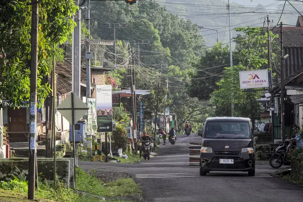 Endonezya, 2 Mei 2025, Tamiajeng, Trawas 'daki bir köy yolunda tipik sabah trafiğine tanık olun. Bölge sakinleri güne başlarken, yerel ve günlük hayatı tecrübe edin..