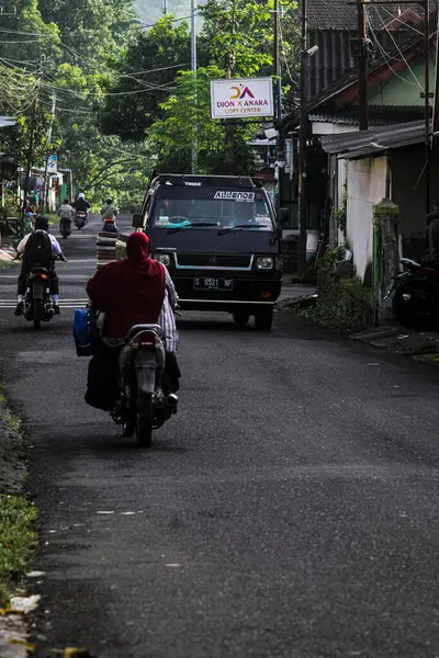 Endonezya, 2 Mei 2025, Tamiajeng, Trawas 'daki bir köy yolunda tipik sabah trafiğine tanık olun. Bölge sakinleri güne başlarken, yerel ve günlük hayatı tecrübe edin..
