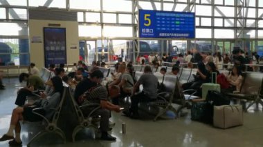 Chengdu, Sichuan, Çin-Aug 24,2024: İnsanlar otobüs durağında el vantilatörüyle Yaz Bayramı 'nın yüksek sıcaklığında bekliyorlar. Otobüs durağının 5 numaralı biletini kontrol et..