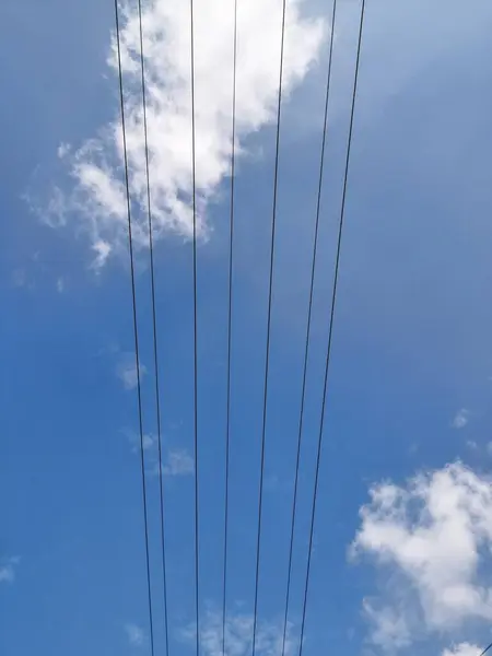 Gökyüzünde elektrik kabloları, yakın plan mavi gökyüzü arkaplanı. Gökyüzüne karşı düşük açılı elektrik kabloları.