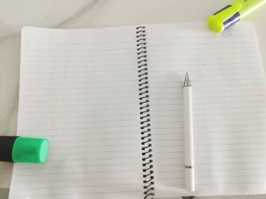 Kalem, sarı ve yeşil keçeli kalemle ahşap zemin ve güneş ışığı üzerine dizüstü bilgisayar manzarası