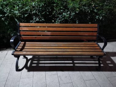 Boş bank, geceleri bir yerleşim bölgesinde sokak lambasıyla aydınlatılıyor.