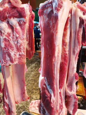 Kapalı markette asılı çiğ domuz eti, kancada domuz eti