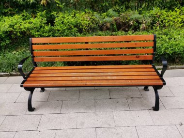 Gündüz vakti halka açık bir alanda boş bir ahşap bank insanların oturup dinlenmesi için..