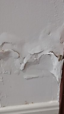 Duvar arkaplan dokusu. Beyaz kabuklu alçı duvar, gevreklerden düşüyor. Düşen beyaz duvar, boyası soyulmuş beyaz duvar..