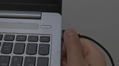 Bilgisayardaki bir porttan bir kablo çıkartılıyor - yakın plan. Fare usb bir dizüstü bilgisayarın portundan çıkıyor.