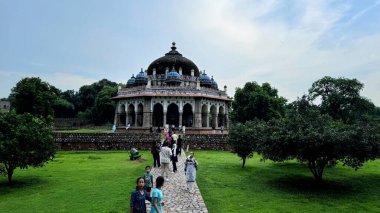 New Delhi, India - August 7, 2024: Humayun's Tomb framed beautifully under an archway, highlighting symmetry and grand scale of Mughal architecture. Humayun's Tomb, Popular Tourist Attraction in Delhi clipart