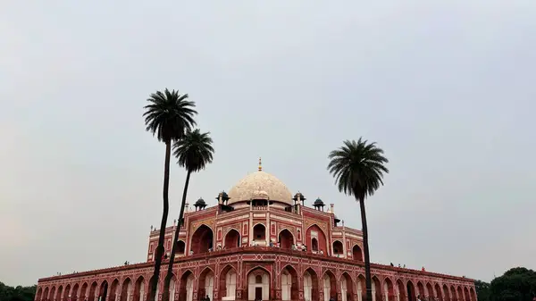 stock image New Delhi, India - August 07, 2024 : Humayun's Tomb framed beautifully under an archway, highlighting symmetry and grand scale of Mughal architecture. Popular Tourist Attraction in Delhi.