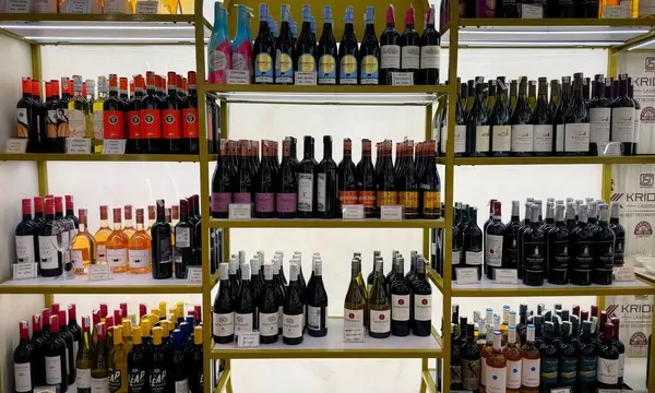 Gurugram, Hindistan - 7 Ağustos 2024: Fransız Şampanyası ve köpüklü şarap şişeleri mağaza raflarında zarif bir şekilde düzenlenmiştir, kutlamalar ve özel günler için mükemmeldir. Satılık ithal şampanya. 