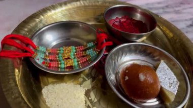 Varanasi, Uttar Pradesh, Hindistan - 24 Eylül 2024: Raksha Bandhan 'ın hazırlanması, rakhis' in dikkatlice festival için bir tabağa yerleştirilmesi, kardeş ve kardeş arasındaki bağı sembolize ediyor.