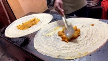 Varanasi, Uttar Pradesh, Hindistan - 24 Eylül 2024: Masala ve paneer ile Hint sokak yiyecek kültürünü vurgulayan, Varanasi, sokak restoranında üçgen şeklinde lezzetli dosyalar hazırlanıyor