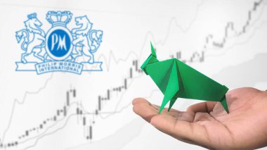 New York - ABD, 25 Aralık 2024: Philip Morris International Stock Uptrend with Selective Focus on green origami Bull, sembolize edilen Philip Morris International Bullish market trendi. Finansal Büyüme kavramını yakalar