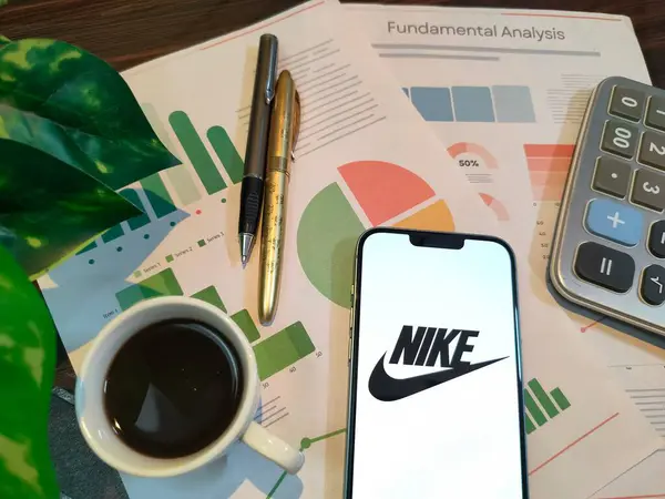 New York, ABD - 15 Aralık 2024: Finansal içgörü için NIKE logosunun bulunduğu grafikler, grafikler, hesap makinesi ve kahvenin yer aldığı NIKE borsa analizine odaklan