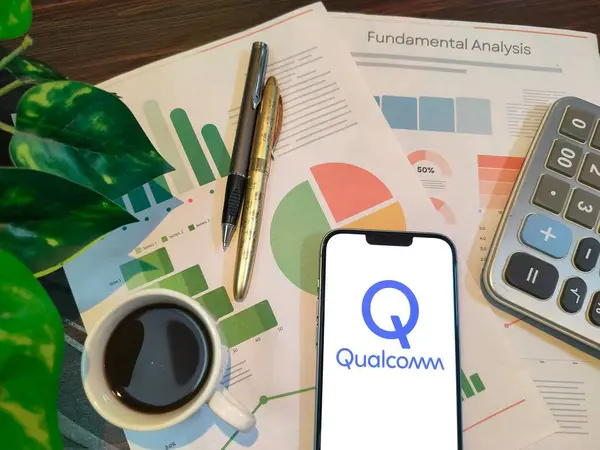 NewYork, ABD - 15 Aralık 2024: QuALCOMM borsa analizi üzerine seçici odaklanma grafikler, grafikler, hesap makinesi ve kahveyle birlikte finansal içgörüler için akıllı bir telefonda