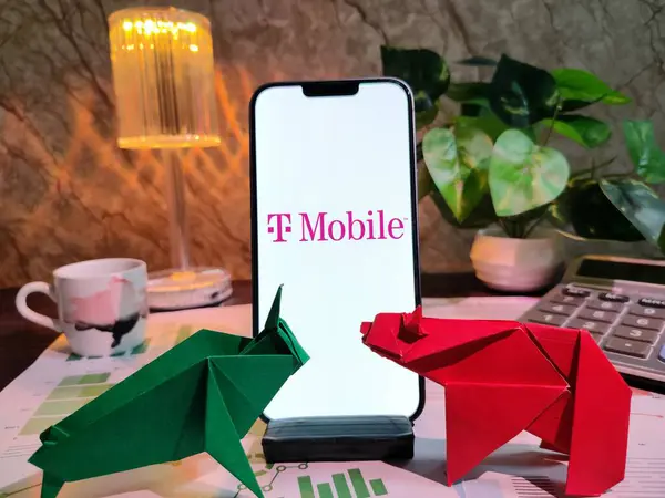 NewYork, ABD - 15 Aralık 2024: Tablolar, grafikler, hesap makineleri ve kahvenin yer aldığı T MOBILE Inc. 'in finansal içgörüler için akıllı bir telefon üzerindeki seçici odak noktası